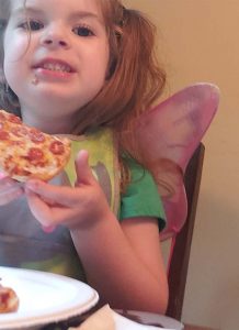 Kid eating bagel pizza