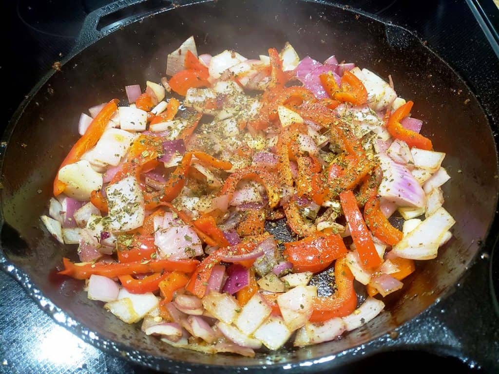 Peppers and Onions cooking in a cast iron pan