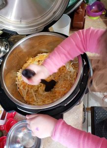 kid making mac and cheese in instant pot