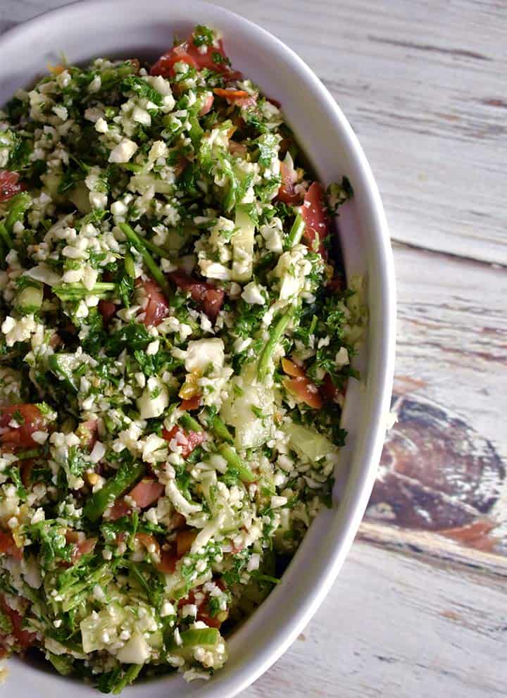 Tabbouleh in a white bowl on a white wooden table