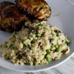 instant pot risotto with chicken on a white plate on white wooden table