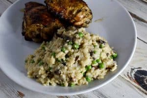 instant pot risotto with chicken on a white plate on white wooden table