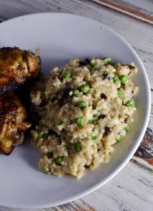 Instant Pot Risotto white mushrooms and green peas on a white plate