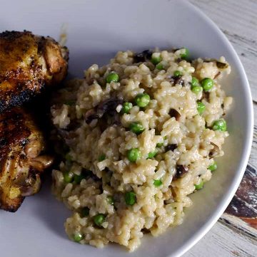 Instant Pot Risotto white mushrooms and green peas on a white plate