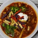 instant pot chicken tortilla soup with sour cream, cilantro, tortilla strips and jalapeno