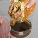 prime rib french dip sandwich with au jus dipping sauce over white table