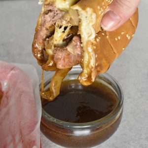 prime rib french dip sandwich with au jus dipping sauce over white table