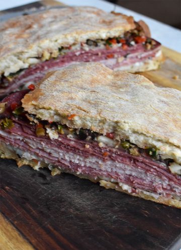 muffaletta sandwich on a wooden cutting board