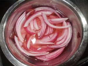 pickled red onions in a metal bowl