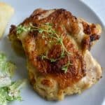 sous vide chicken thighs on a white plate - for pinterest