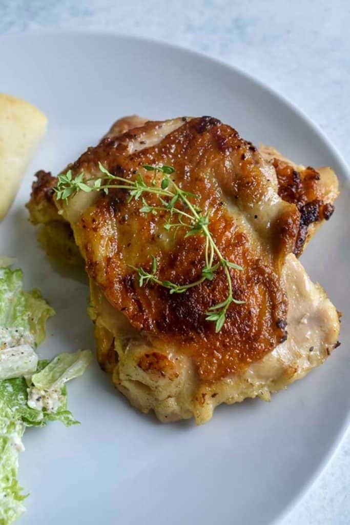 sous vide chicken thighs on a white plate - for pinterest