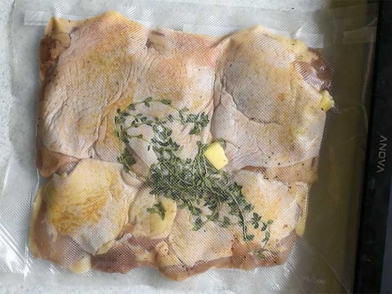 chicken thighs in a sous vide bag with butter and thyme