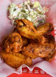 buffalo chicken wings in a food service basket with salad