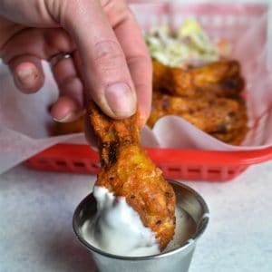chicken wing being dipped in bleu cheese dressing