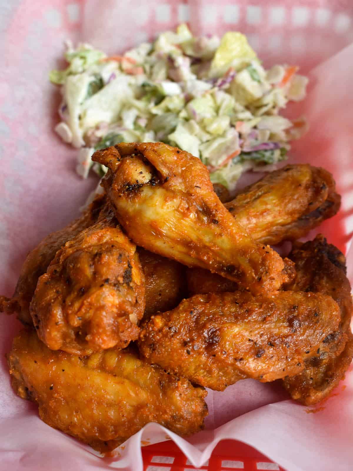 buffalo chicken wings in a food service basket with salad