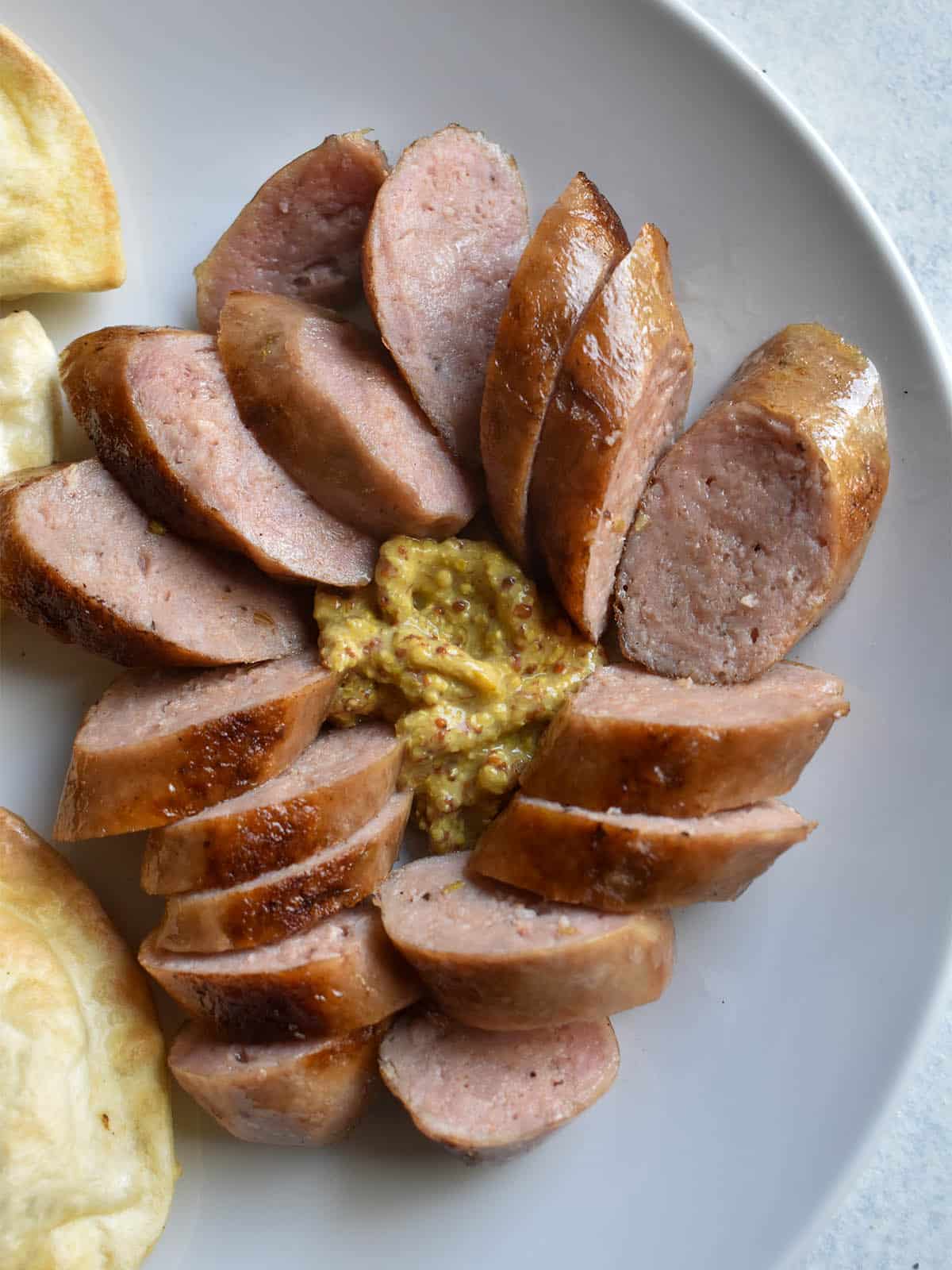 sausage with whole grain mustard on a white platedijon mustard