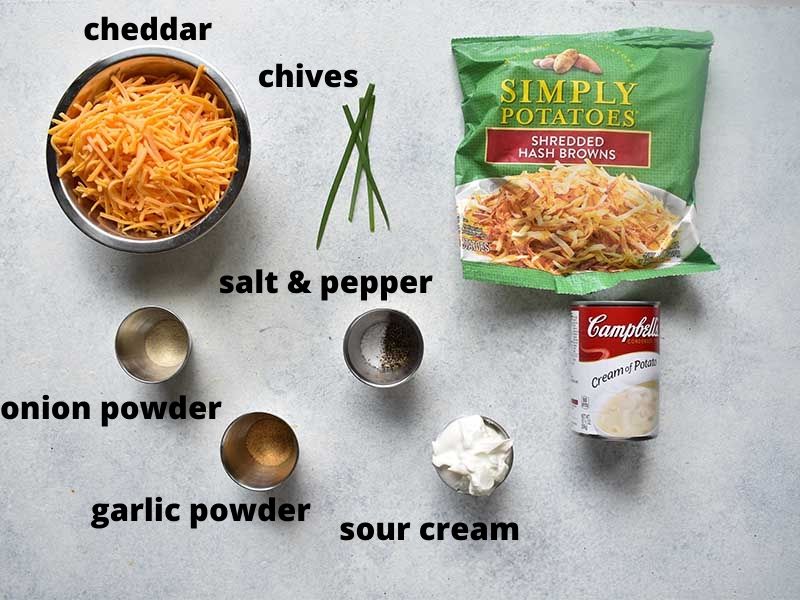 ingredients for cheesy potatoes sitting on a white table