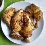 carved chicken on a white plate with a green napkin