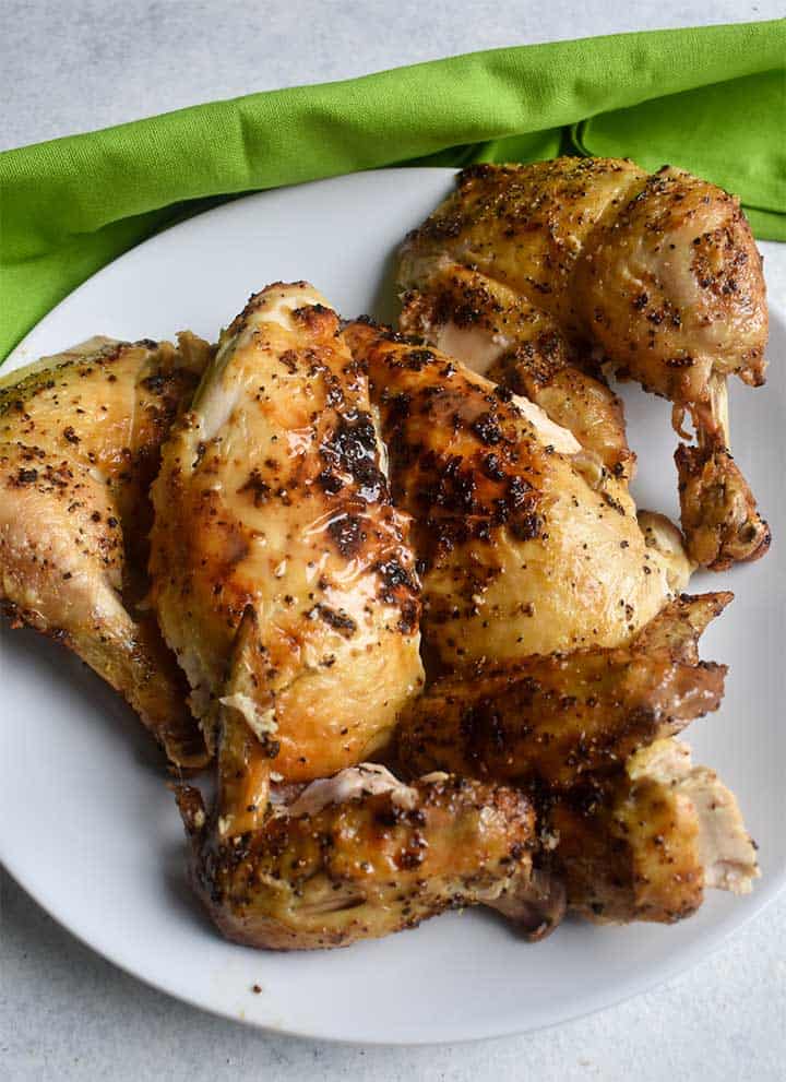 carved chicken on a white plate with a green napkin