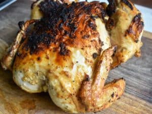 cooked chicken sitting on a wooden cutting board