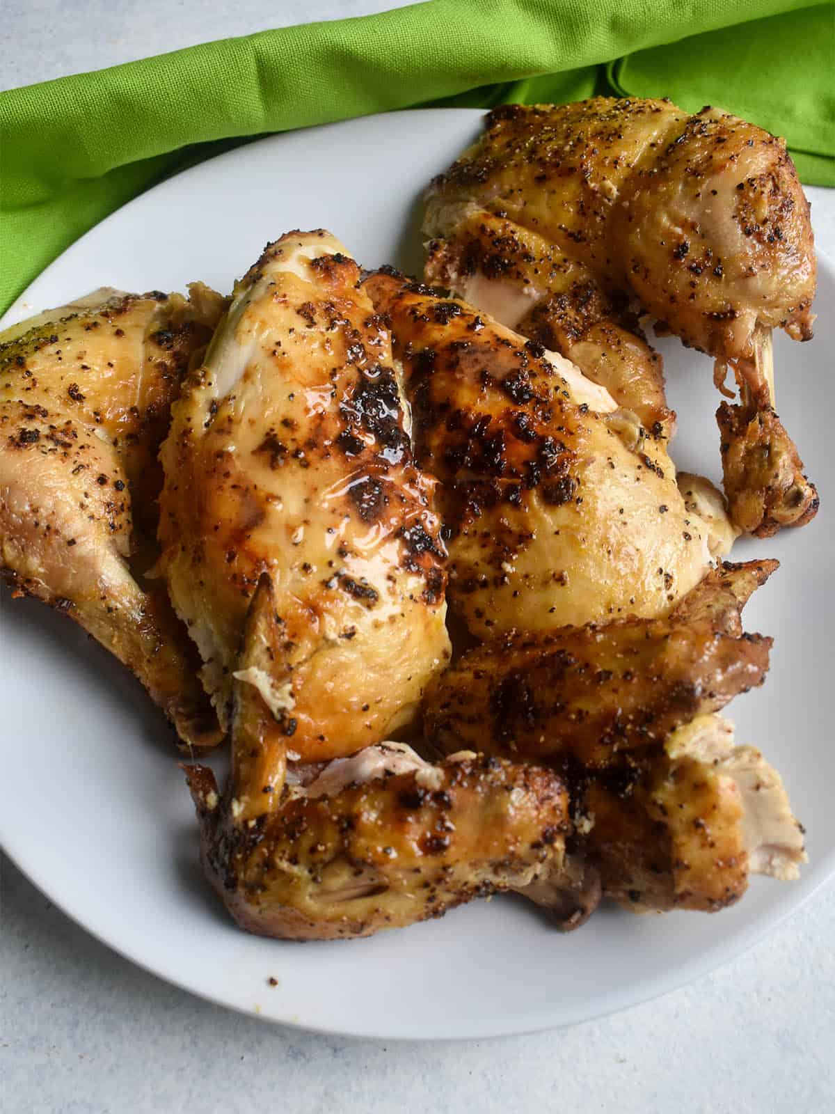 roasted chicken on a white plate with a green napkin