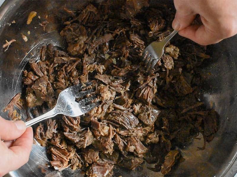 beef being shredded by forks