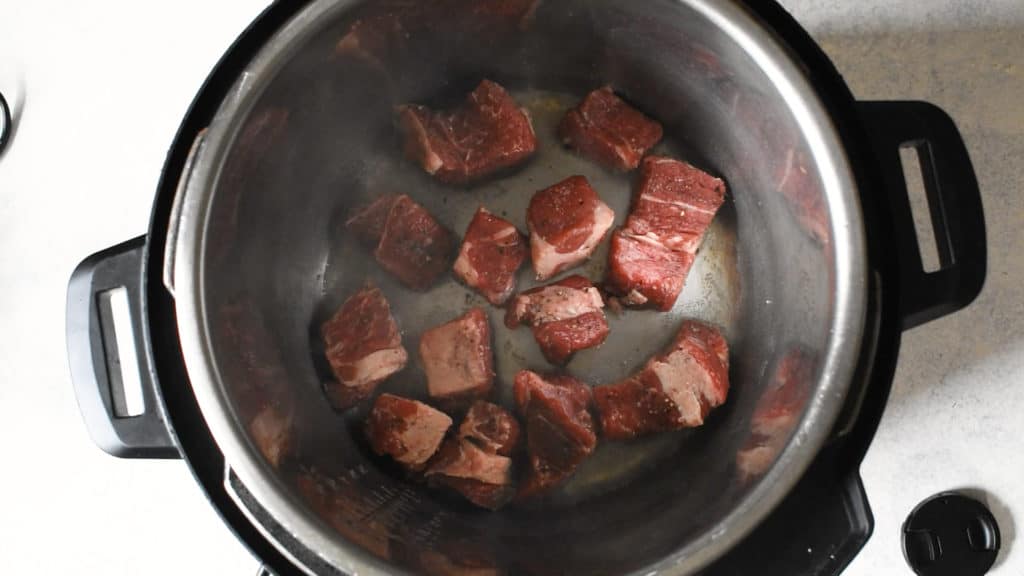 beef chunks being seared in an instant pot