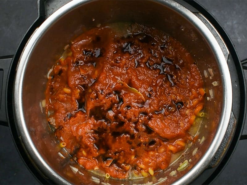 crushed tomatoes with soy sauce sitting on top of noodles in an instant pot